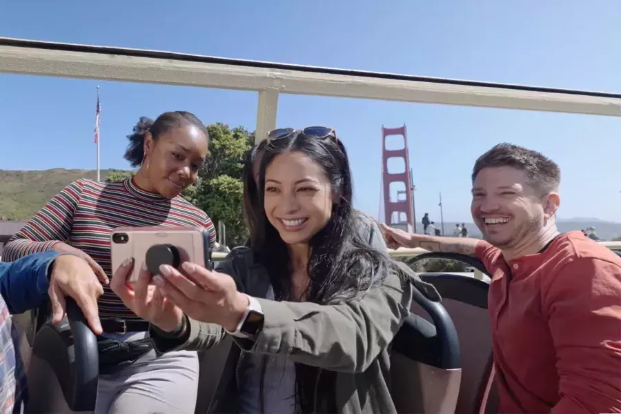 A group of visitors take a selfie on a bus tour near the 金门大桥. 贝博体彩app，加州.